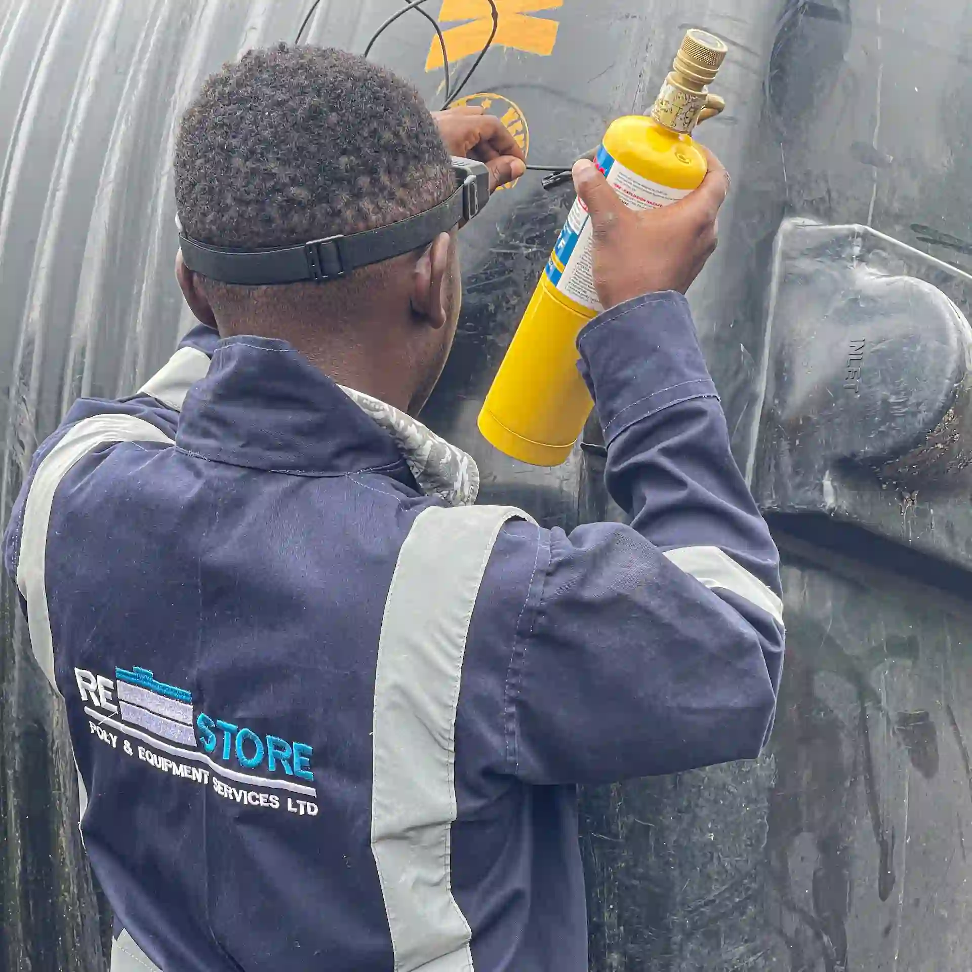 Restore Services plastic tank repair technician welding a damaged tank in Kenya