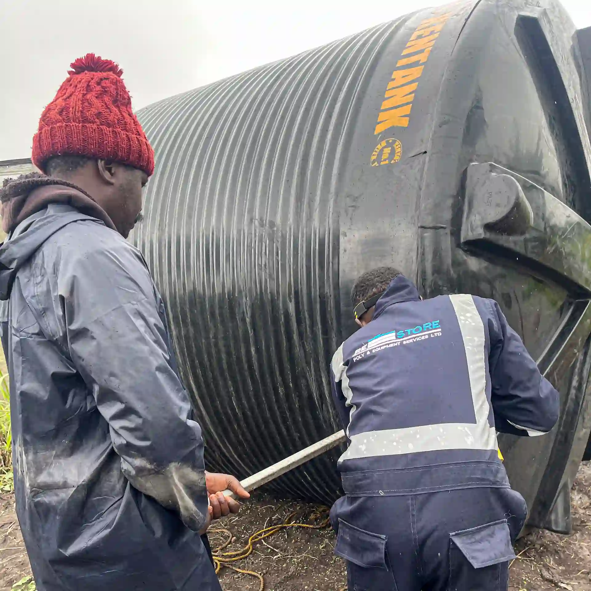 Restore Services technicians repairing a large plastic water tank on site in Kenya