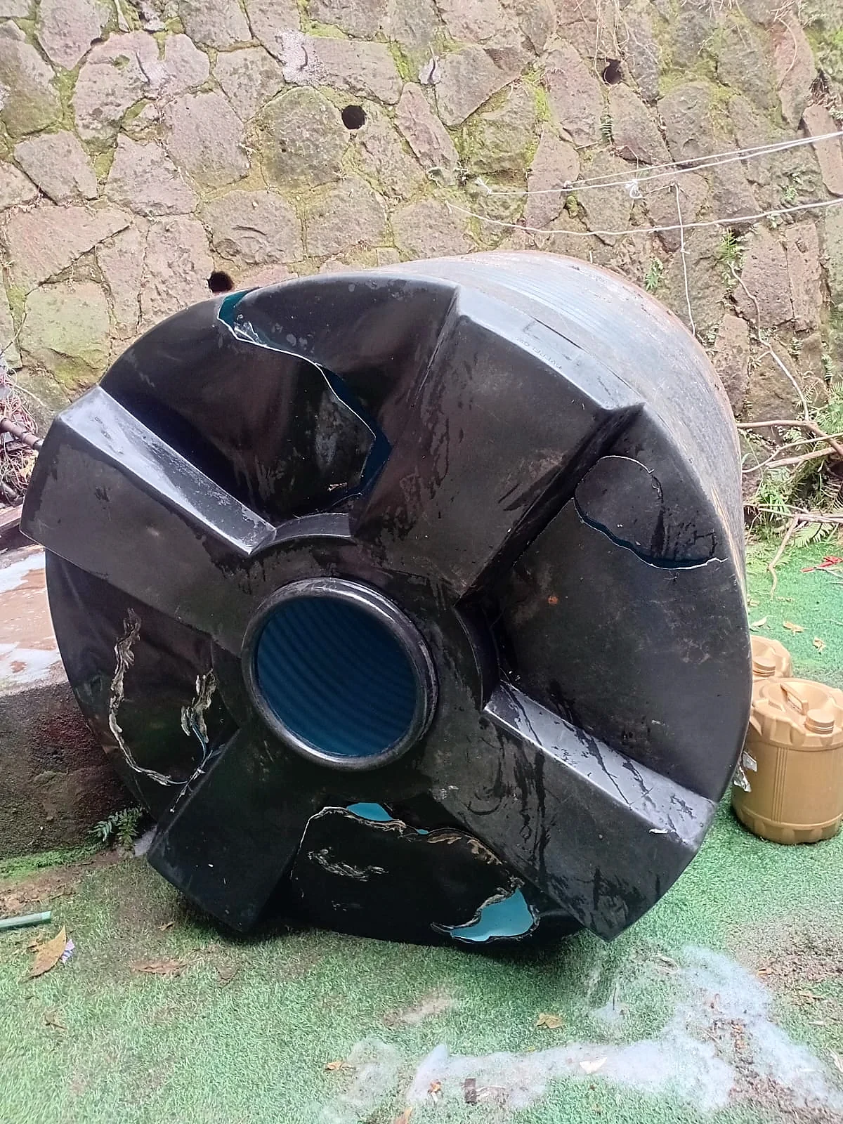 A split black tank welded and restored — before repair